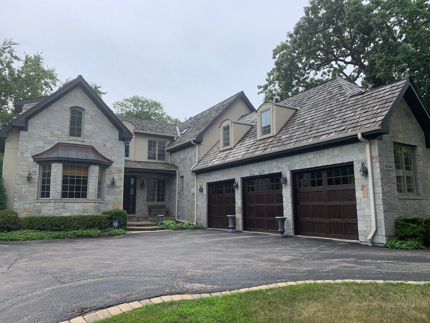 A large house with three garage doors and a driveway