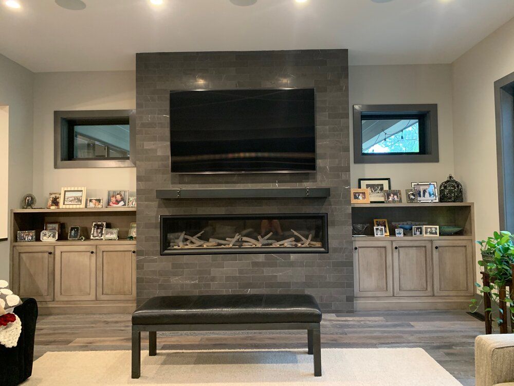 A living room with a fireplace and a flat screen tv on the wall.