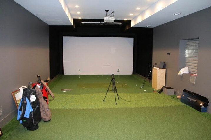 There is a golf simulator in the middle of the room.