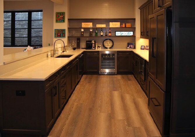 A kitchen with a refrigerator , sink , and shelves.