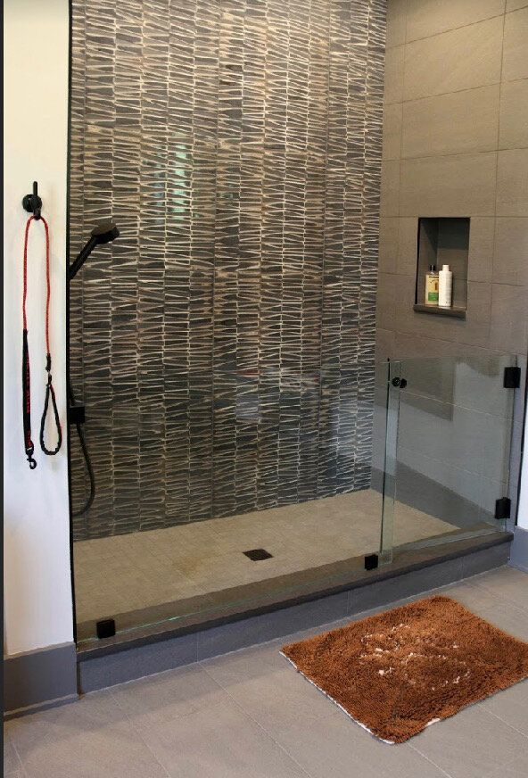 A bathroom with a walk in shower and a rug.