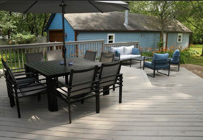 A deck with a table and chairs under an umbrella