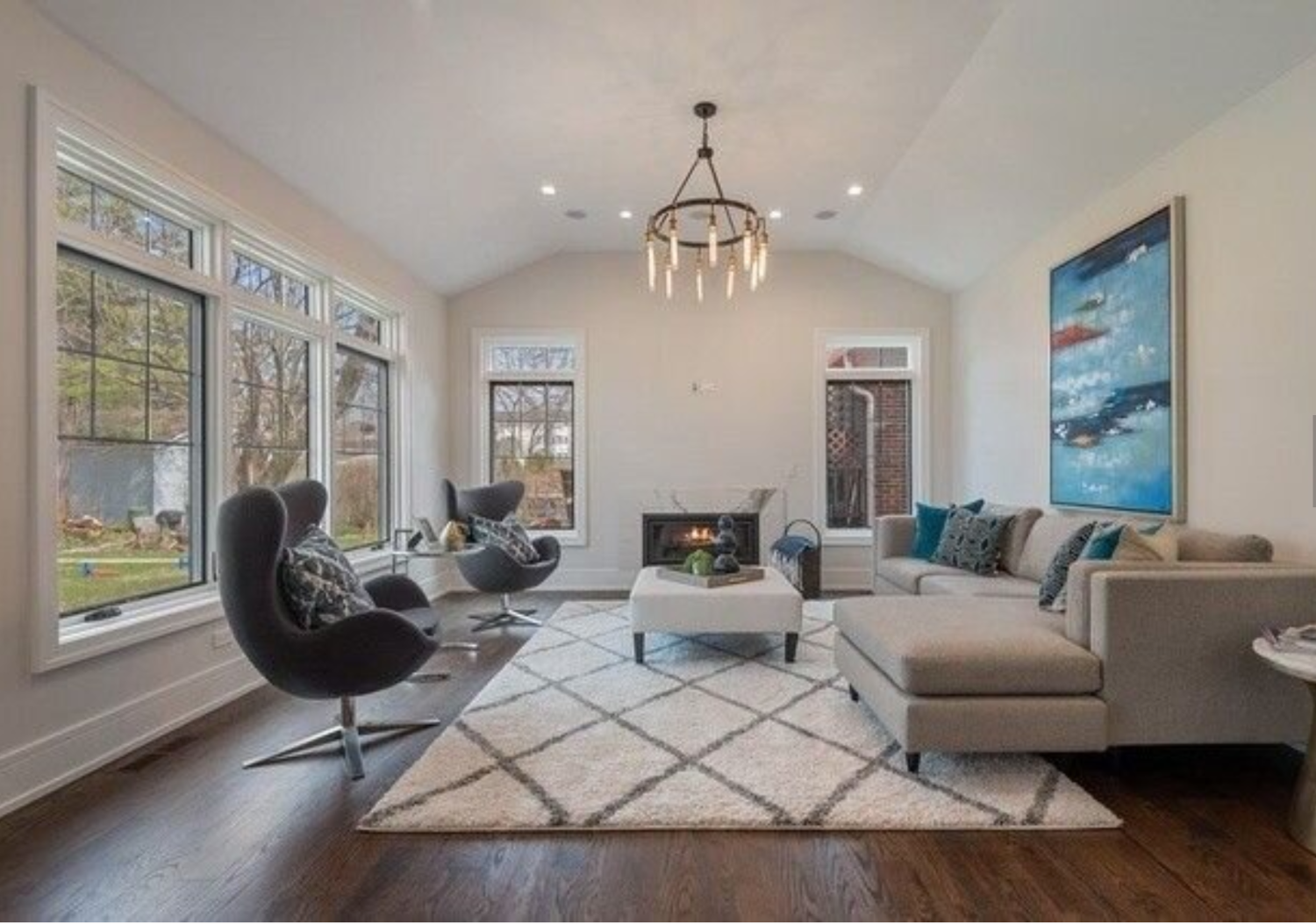 A living room with a couch , chairs , coffee table and fireplace.