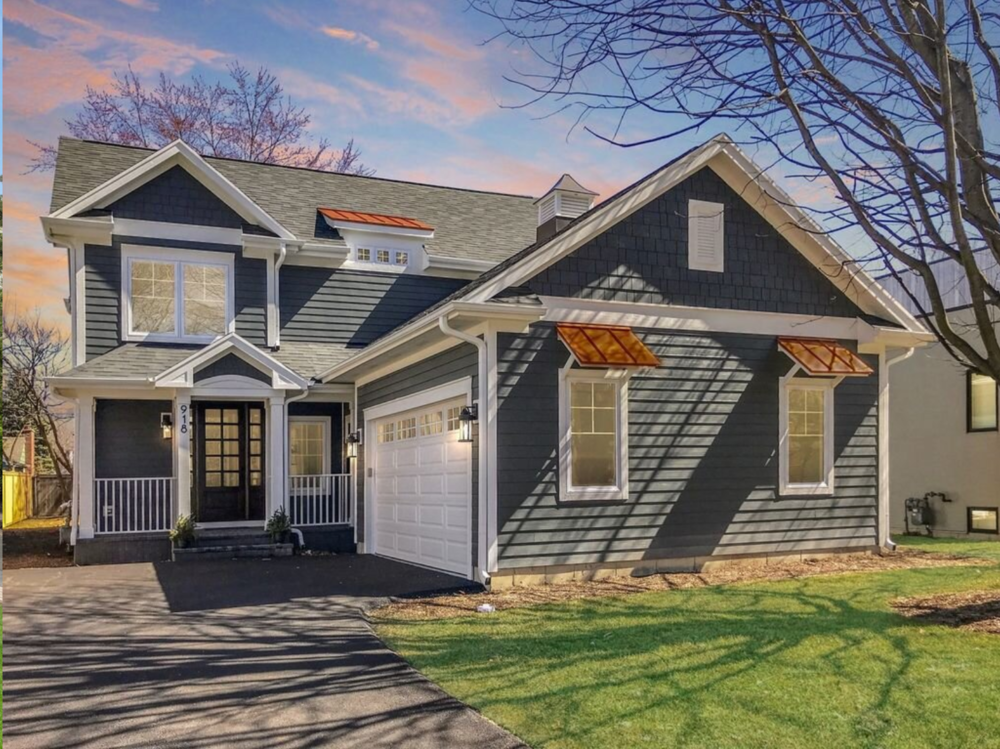A house with a gray siding and a white garage door