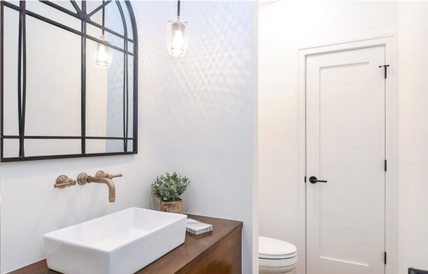 A bathroom with a sink , toilet and mirror.