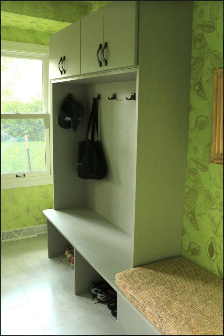 A room with green walls and white cabinets and a bench