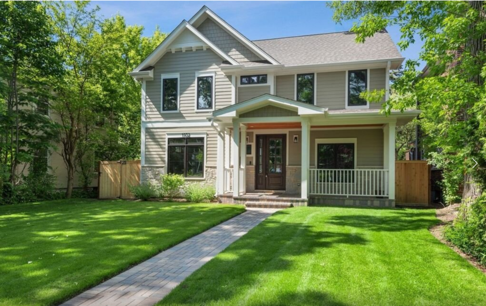 A house with a lush green lawn and a walkway leading to it