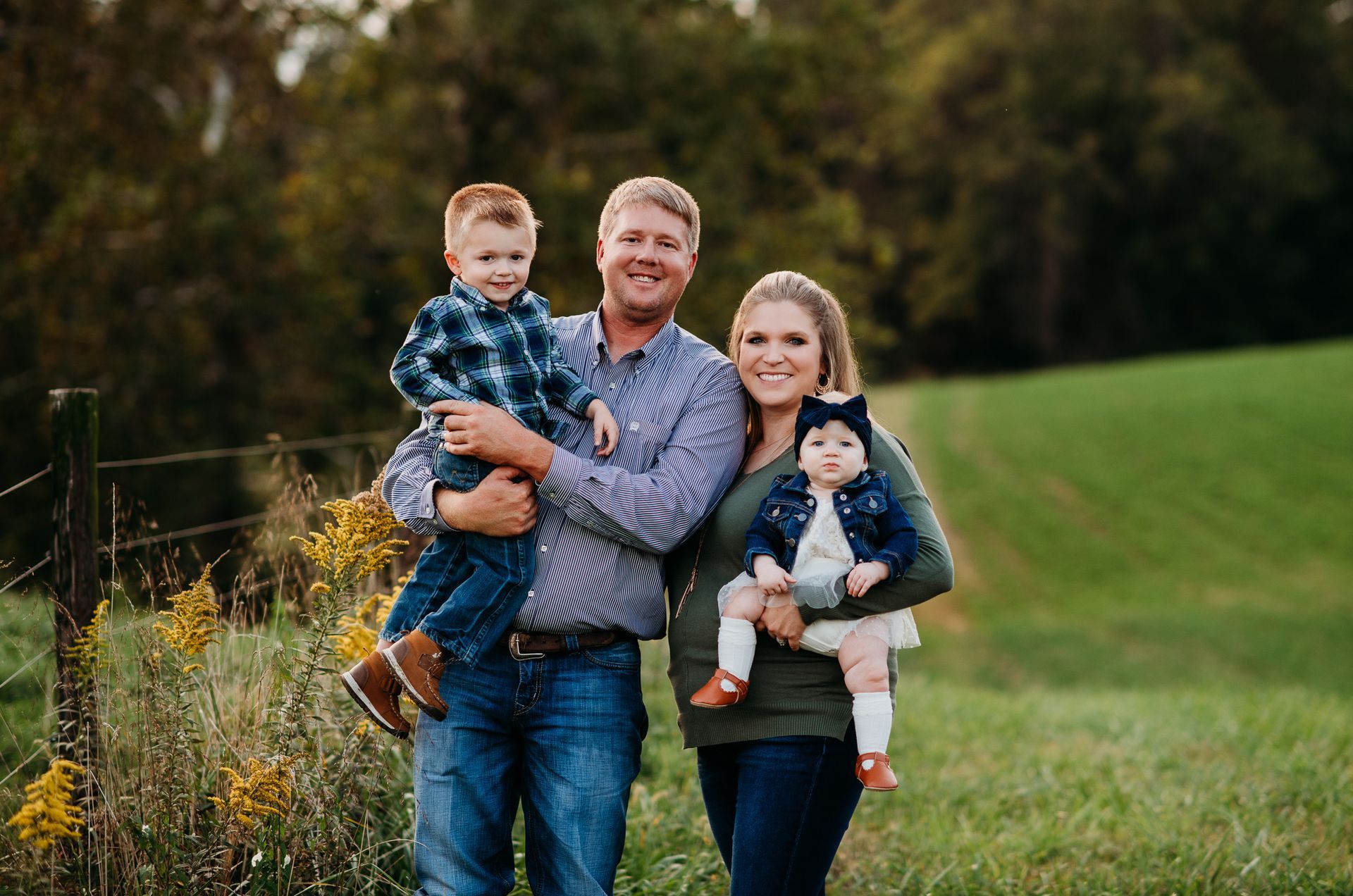 A family is posing for a picture in a field.