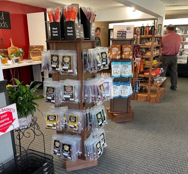 A man is standing in a store looking at a display of snacks