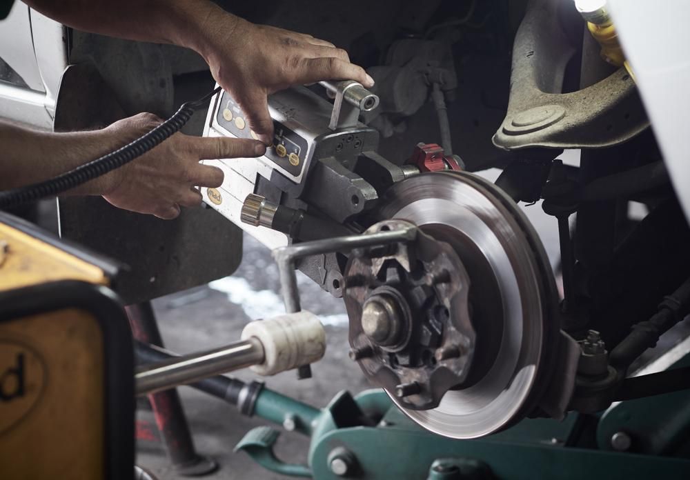 Mechanic Working on A Car's Brake Disc — Triple C Workshop in Springwood, QLD