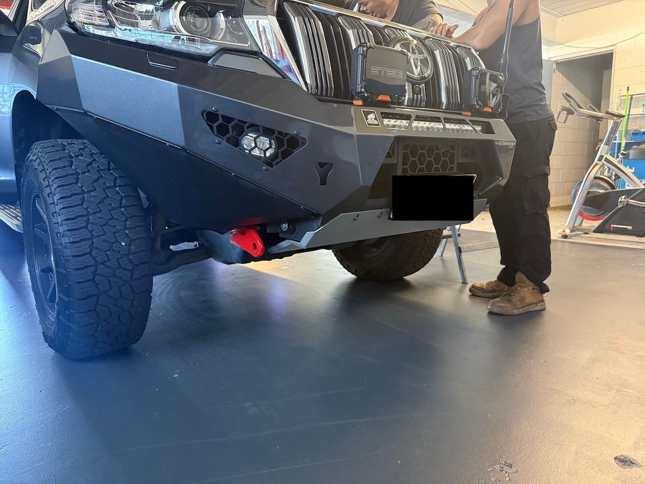 Black Suv with A Custom Bumper Being Worked on Indoors a Person Stands Nearby — Triple C Workshop in Springwood, QLD