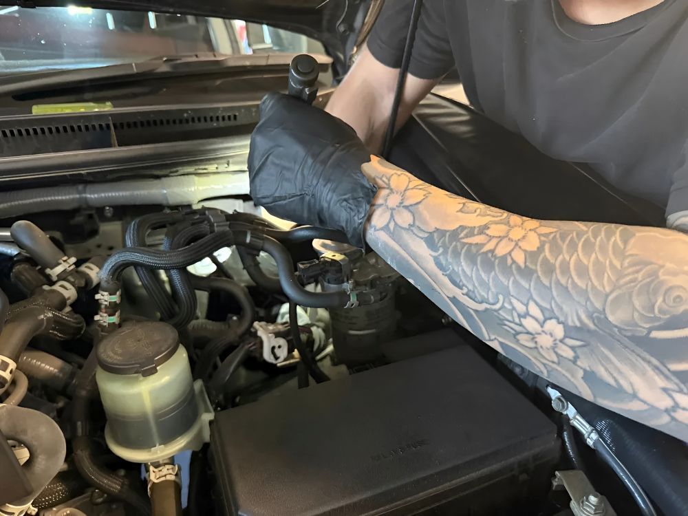 Person with Sleeve Tattoo Working on A Car Engine — Triple C Workshop in Springwood, QLD