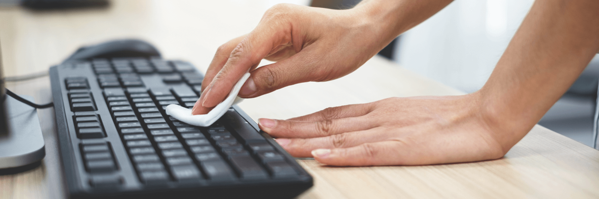 Close up of a woman's hands touching and cleaning a keyboard, computer keyboard clean and disinfecting