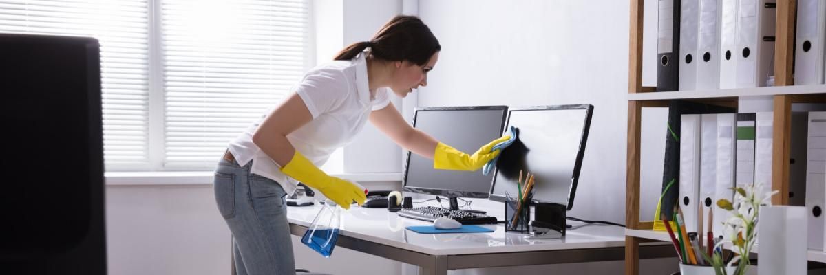 cleaning woman cleaning an office computer screen