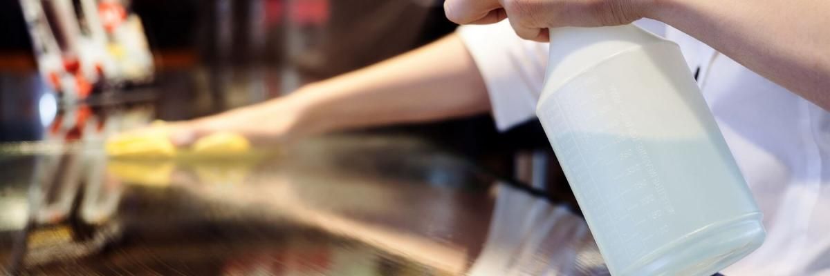 commercial cleaner wiping down restaurant bartop