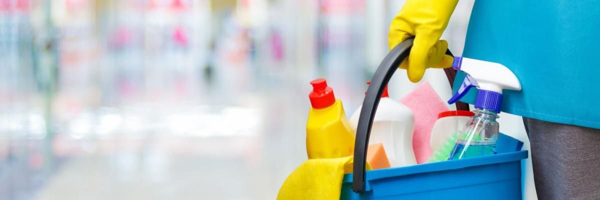 cleaner holding bucket of cleaning supplies