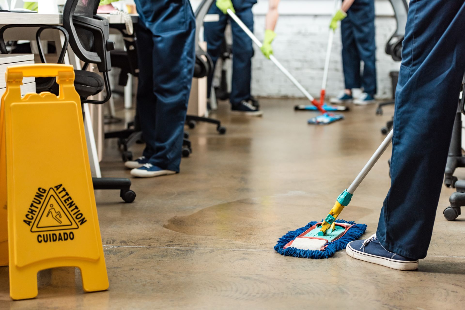 A group of janitors are cleaning an office floor.