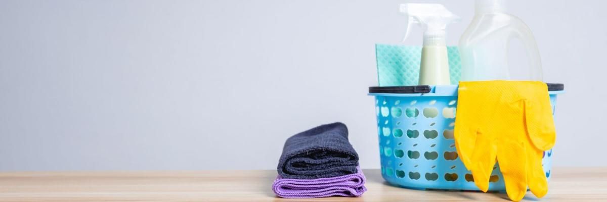 rags and a basket of cleaning supplies on table