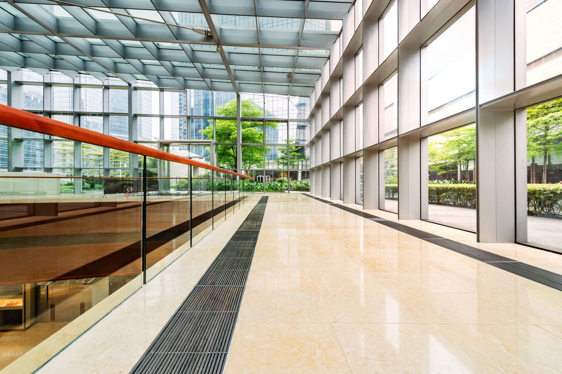 An empty hallway in a large building with lots of windows.