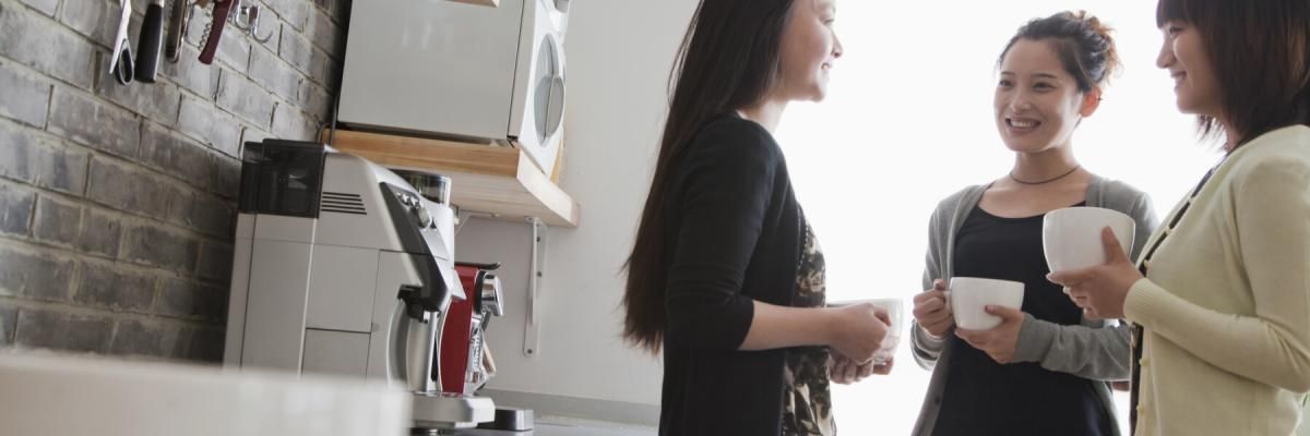 Three women on coffee break in the office kitchen