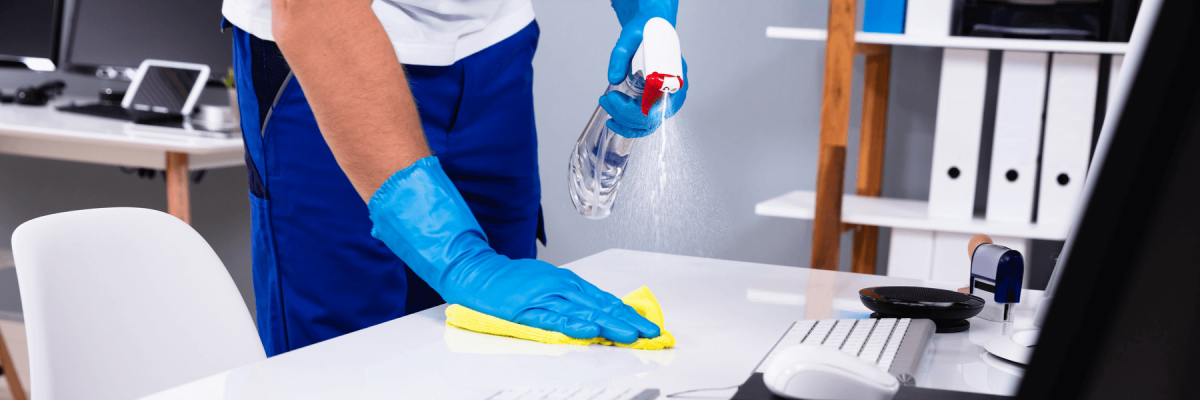 Professional cleaner wiping down an office desk