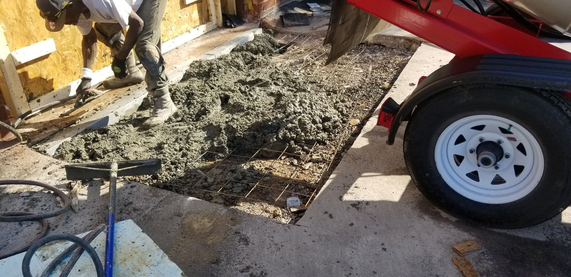 a man is pouring concrete into a hole in the ground .