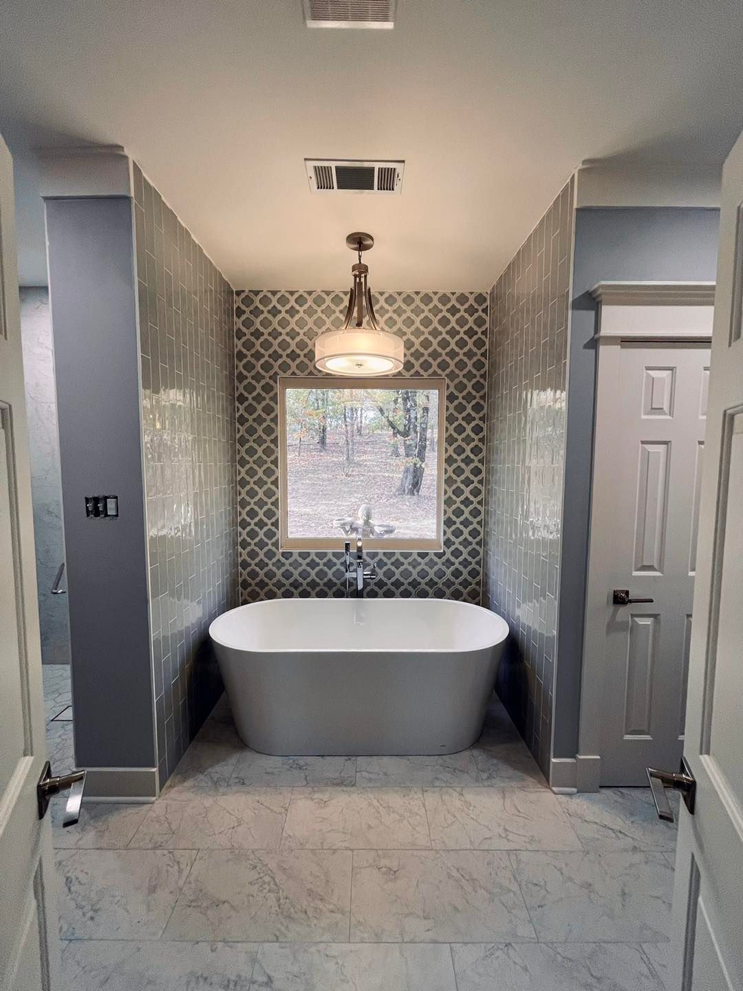 A bathroom with a bathtub and a window.
