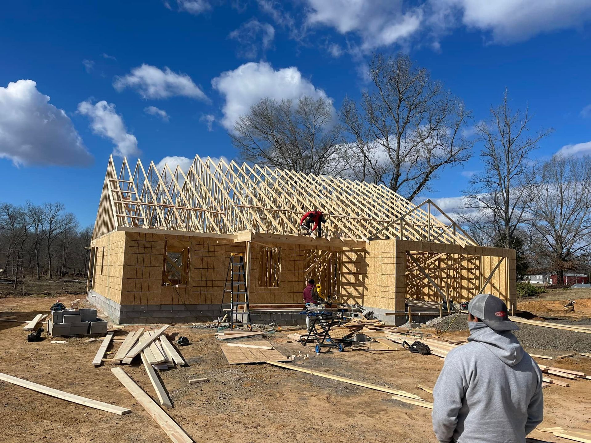 A man is standing in front of a house under construction.