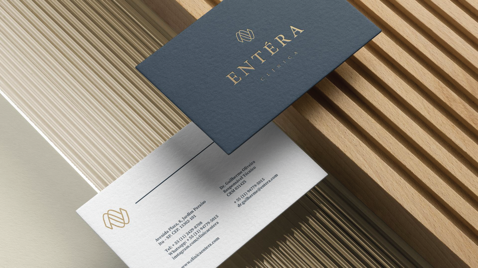 A business card for entera is sitting on a wooden table.