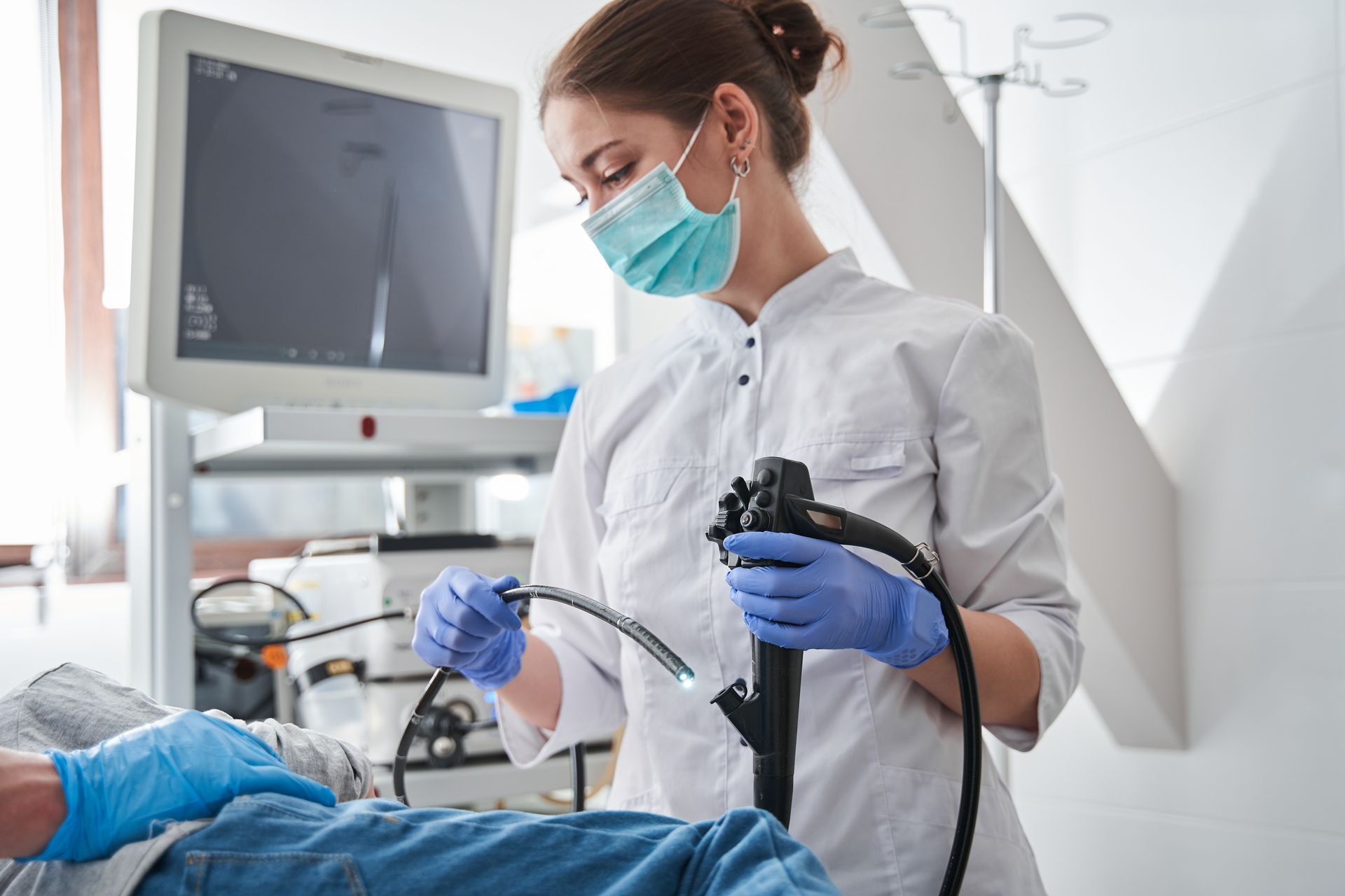 A female doctor is using an endoscope on a patient.