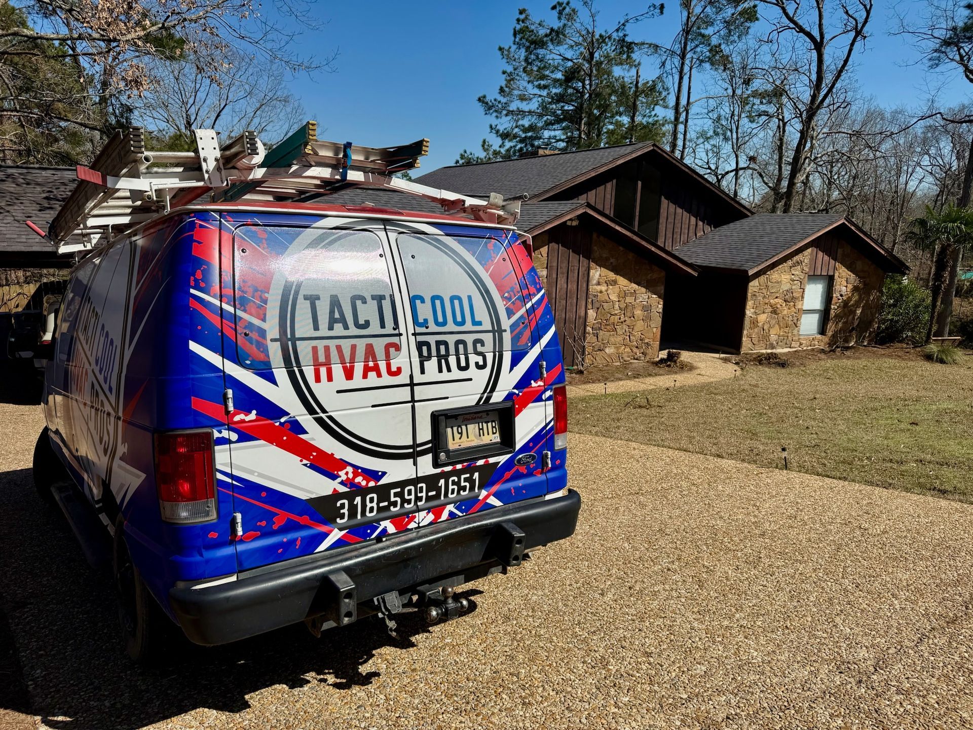 Blue and red HVAC van parked in front of a house, company logo is 