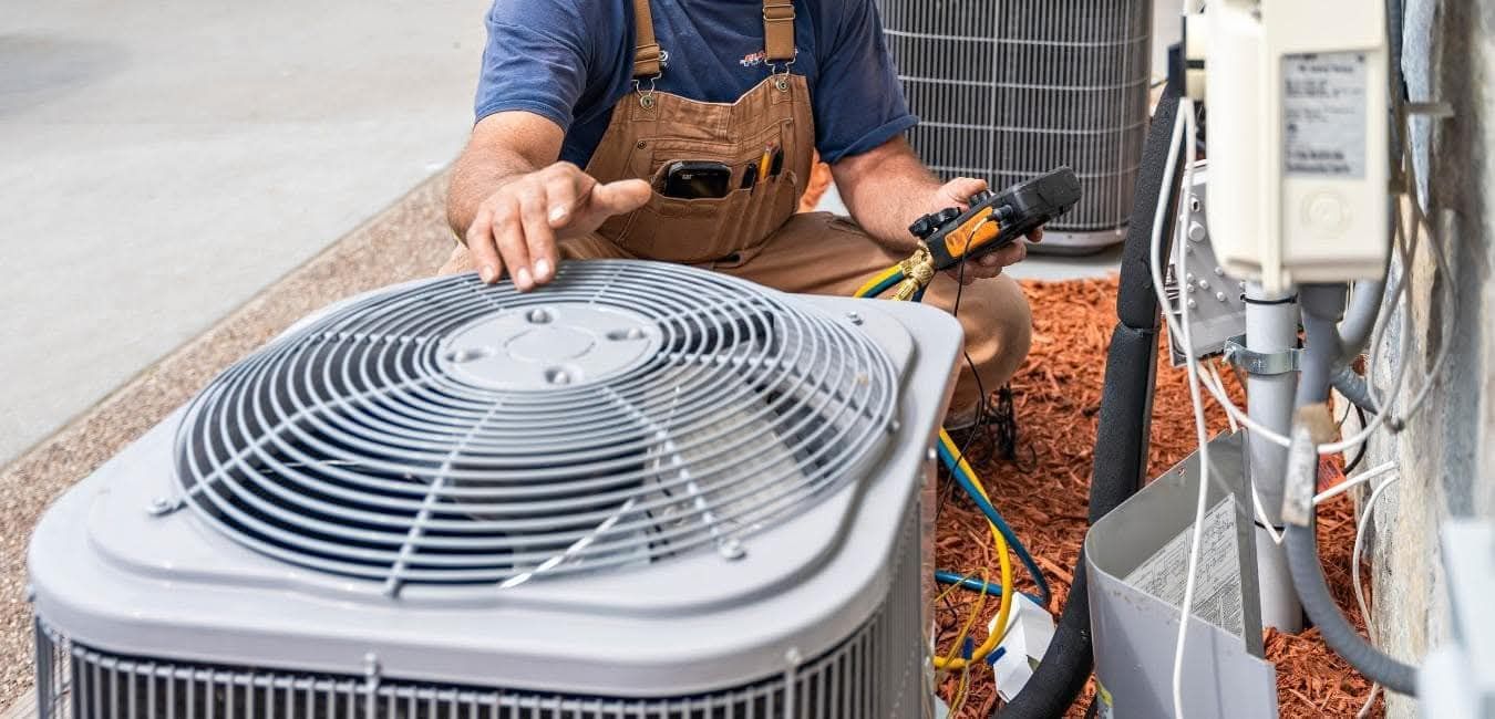 An HVAC technician repairing an air conditioning unit.