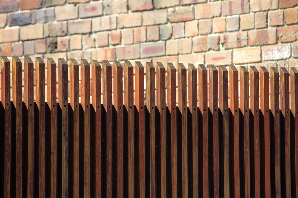 Wooden Slat Fence in Front of a Brick Wall — Capital Fencing in Charnwood, ACT