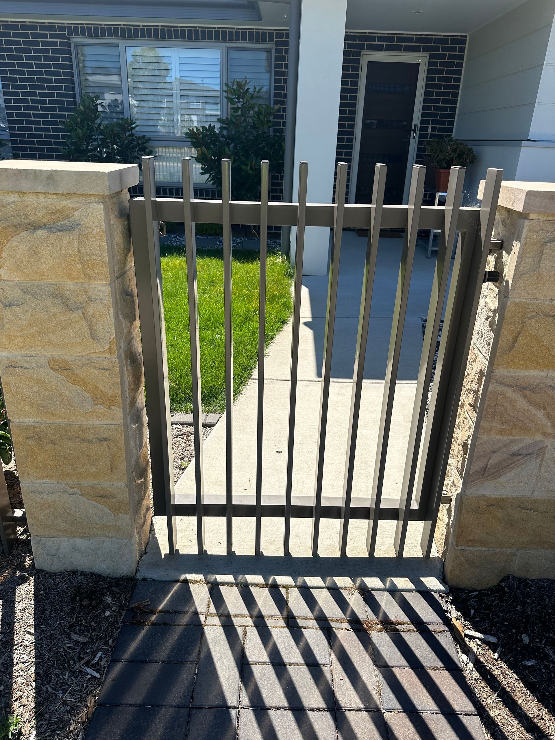 Modern Slat Fencing Gate Between Stone Pillars  — Capital Fencing in Charnwood, ACT