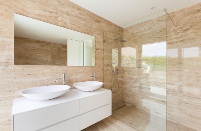 Modern bathroom with white vanity, sinks, mirrors, and a shower/tub combo.