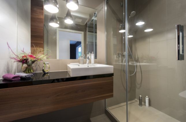 Modern bathroom with white vanity, sinks, mirrors, and a shower/tub combo.