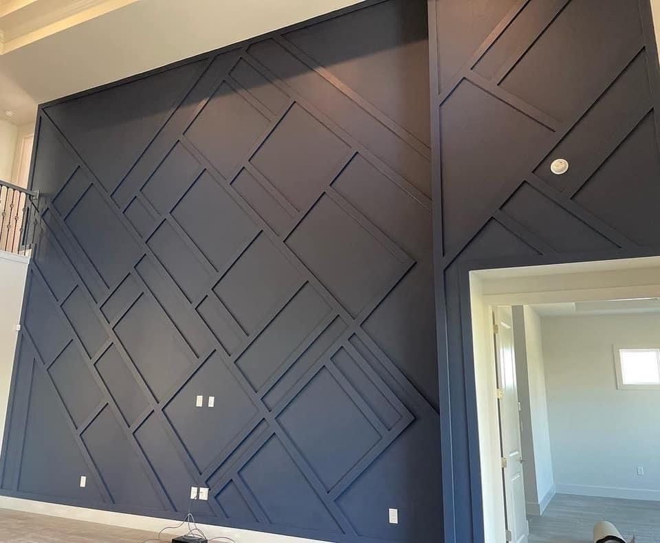 Dark blue accent wall with geometric molding.