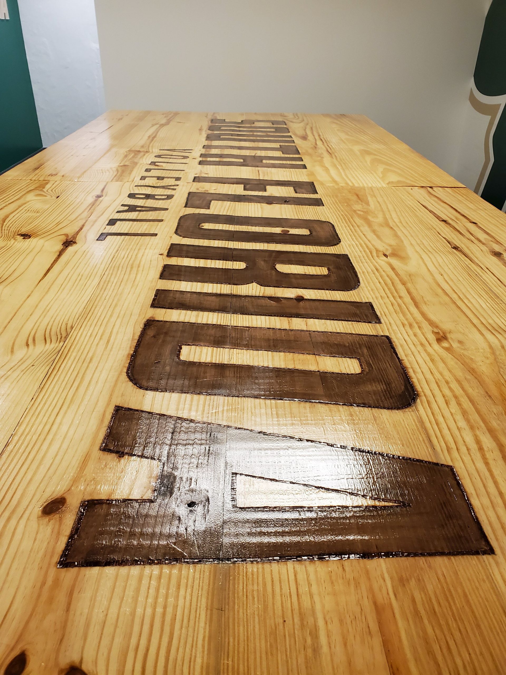 Wooden table with dark brown lettering spelling 