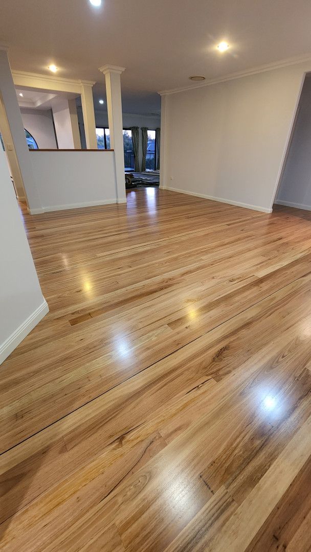 An Empty Room With a Wooden Floor and Two Windows — Shane Callinan Floor Sanding In North Haven, NSW