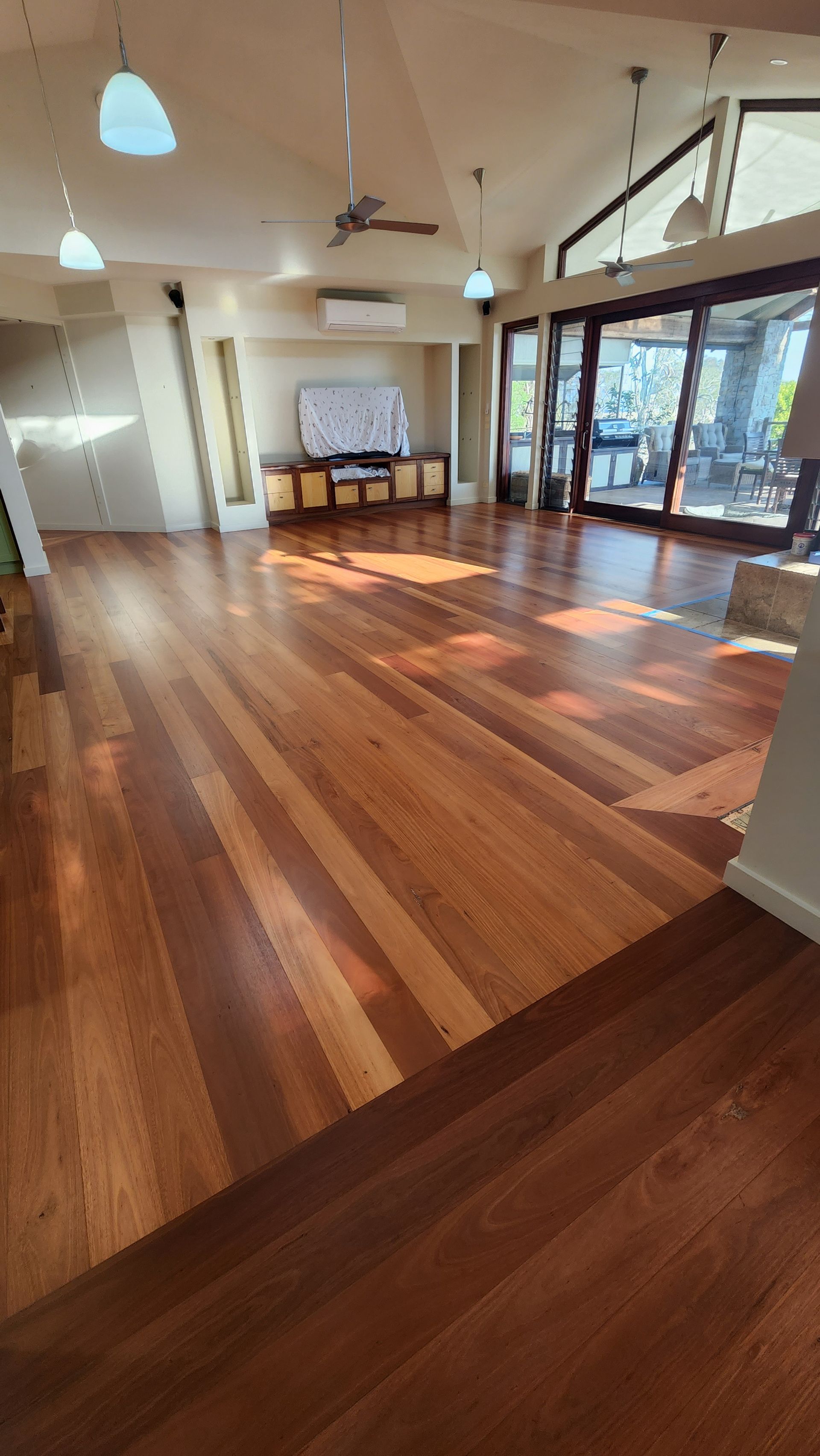 A Wooden Floor in a Living Room With a Dresser and Chairs — Shane Callinan Floor Sanding In North Haven, NSW