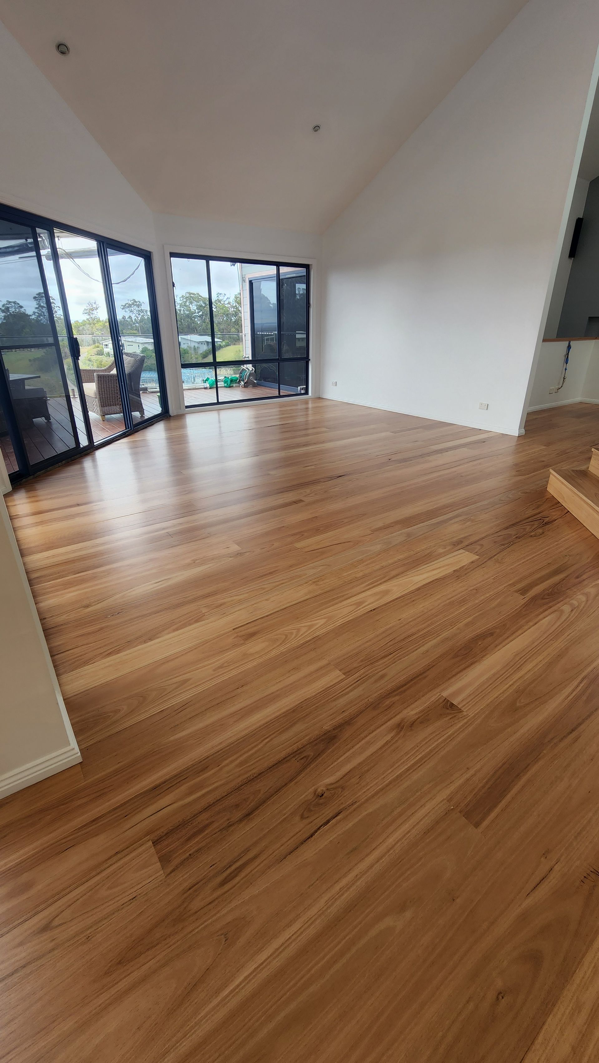 A Person is Laying a Piece of Wood on a Wooden Floor — Shane Callinan Floor Sanding In North Haven, NSW