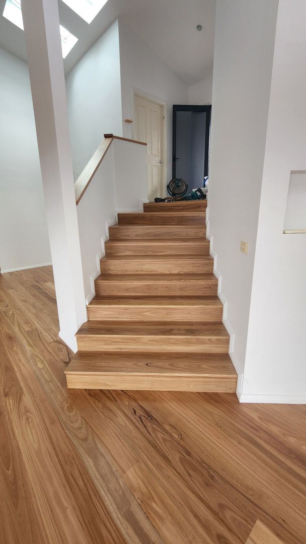 A Living Room With a Couch , Chairs , Stairs and a Fireplace — Shane Callinan Floor Sanding In North Haven, NSW