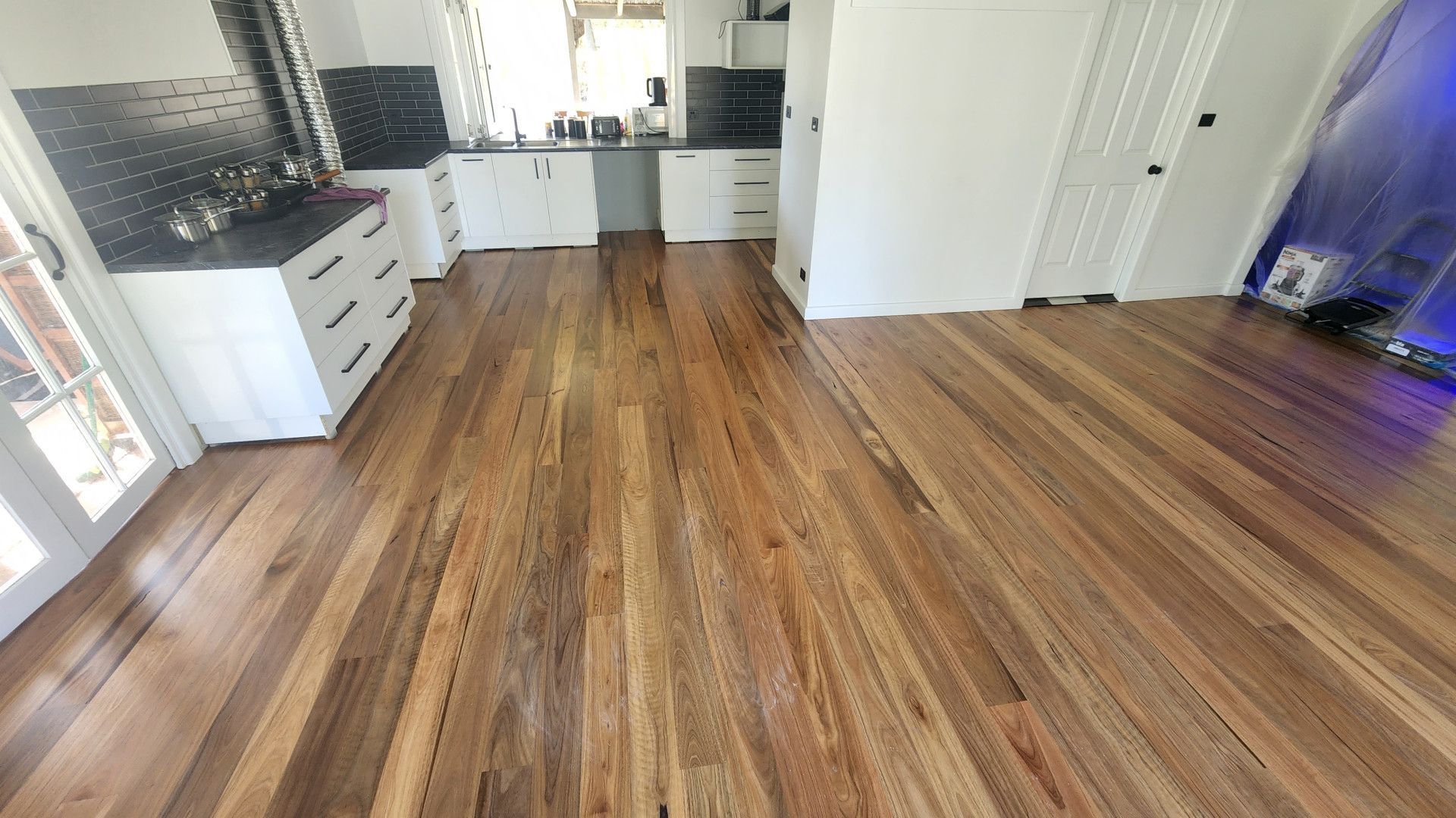 A Stainless Steel Floor Vent is Sitting on a Wooden Floor Next to a Window — Shane Callinan Floor Sanding In Taree, NSW