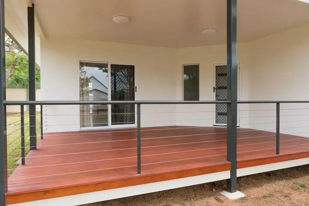 A Porch With a Wooden Deck and a Metal Railing — Shane Callinan Floor Sanding In Bonny Hills, NSW