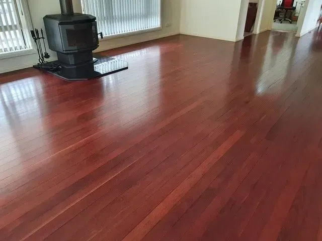 A Living Room With Hardwood Floors and a Wood Stove — Shane Callinan Floor Sanding In South West Rocks, NSW