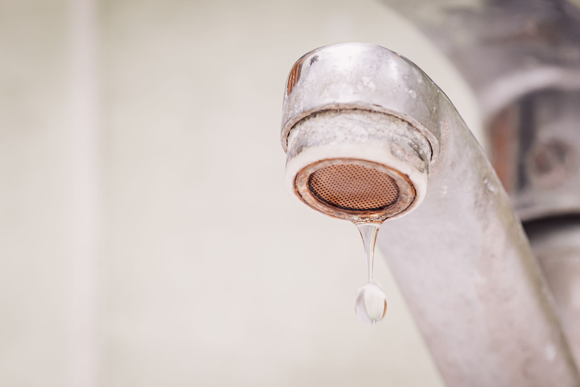 Close up of water dripping from a dirty tap with calcium and rust.