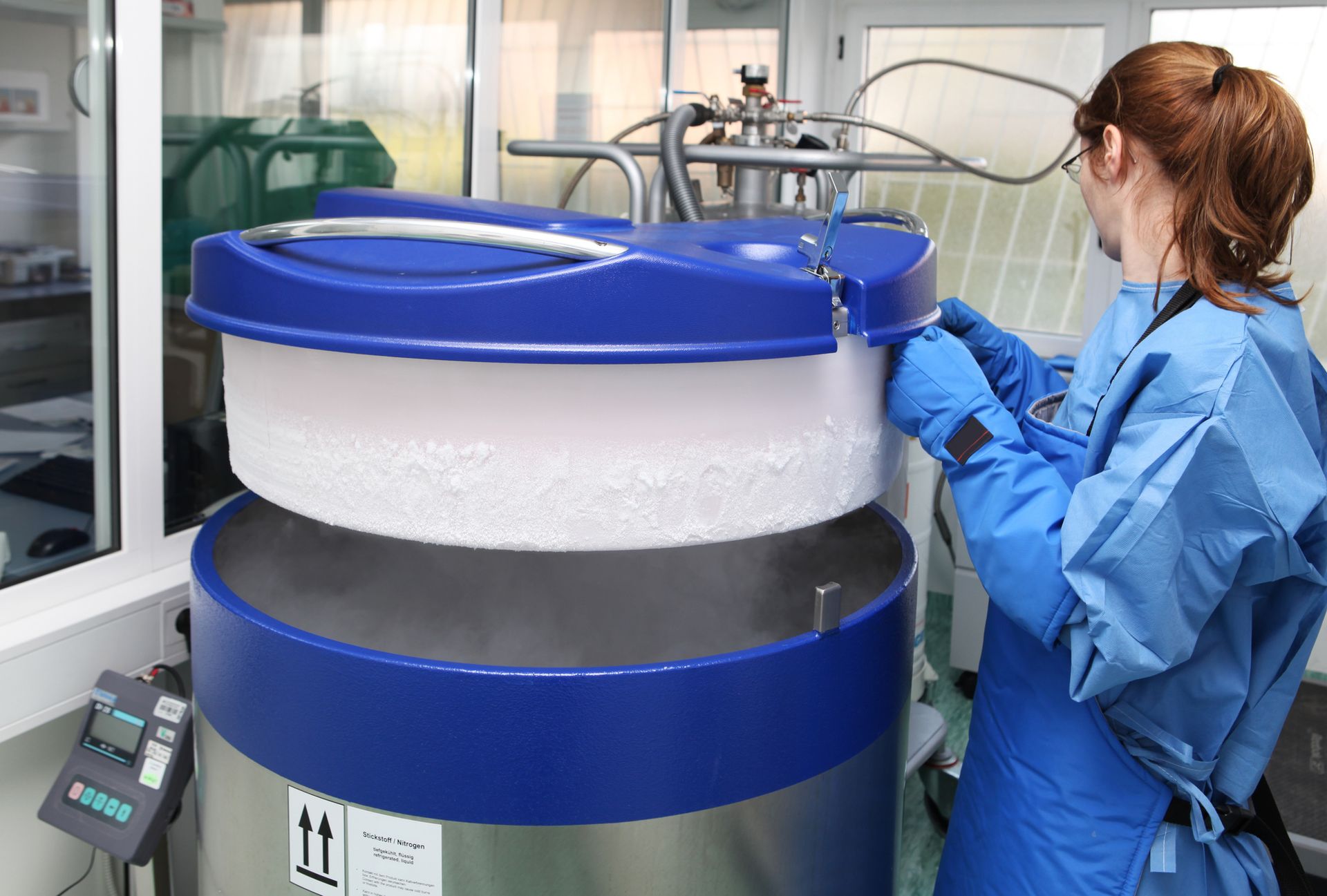 Technician in lab coat inspects water softening equipment in sterile lab environment. Technician in lab coat inspects water softening equipment in sterile lab environment.
