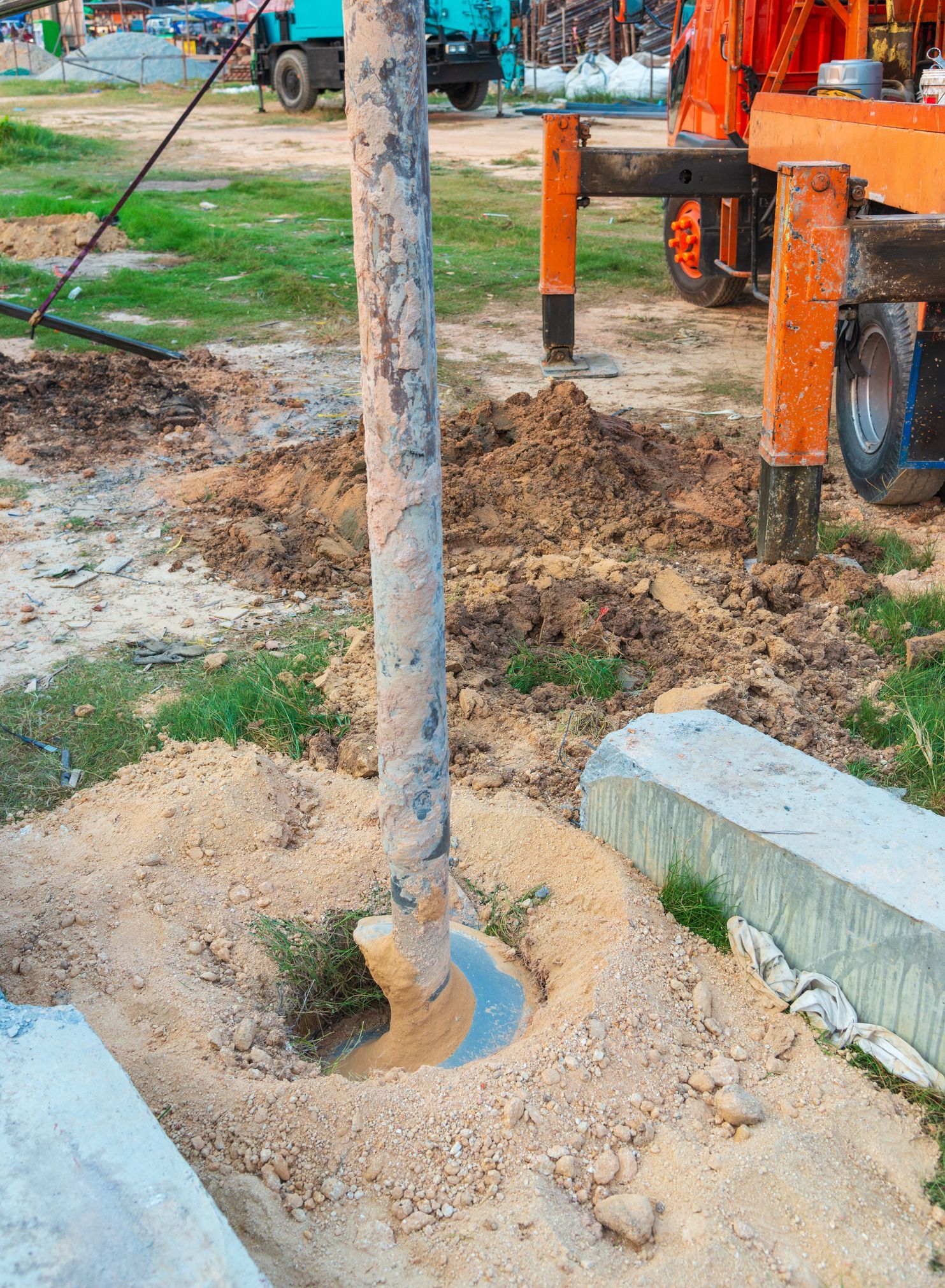 Pipe insertion process by commercial well drilling contractor in muddy construction zone