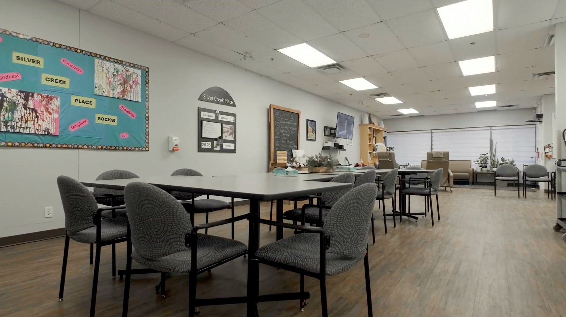 Large room with tables, chairs, and decorations; likely a community center or activity room.
