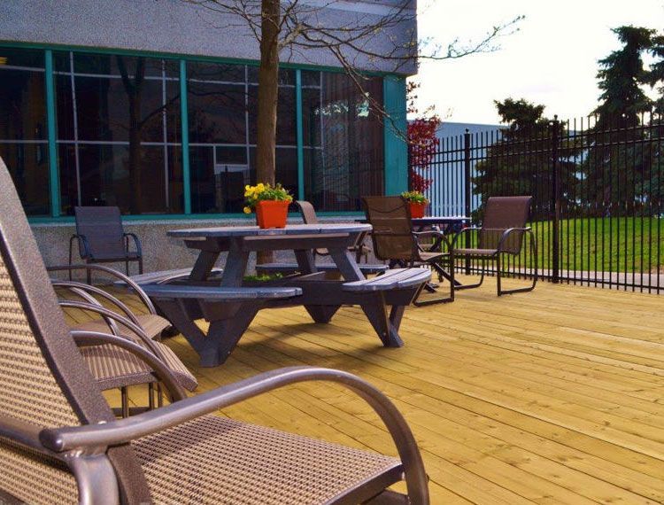A wooden deck with a picnic table and chairs